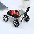 Assembled DIY wind car science experiment kit with acrylic, metal, and plastic parts on a table.