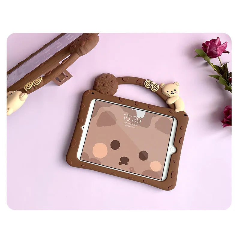 Brown cartoon-design silicone sleeve with integrated stand, fitted on an iPad tablet.