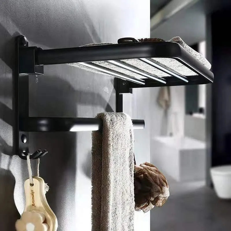 Silver aluminium two-tier folding towel rack with perforated shelves mounted on a bathroom wall.