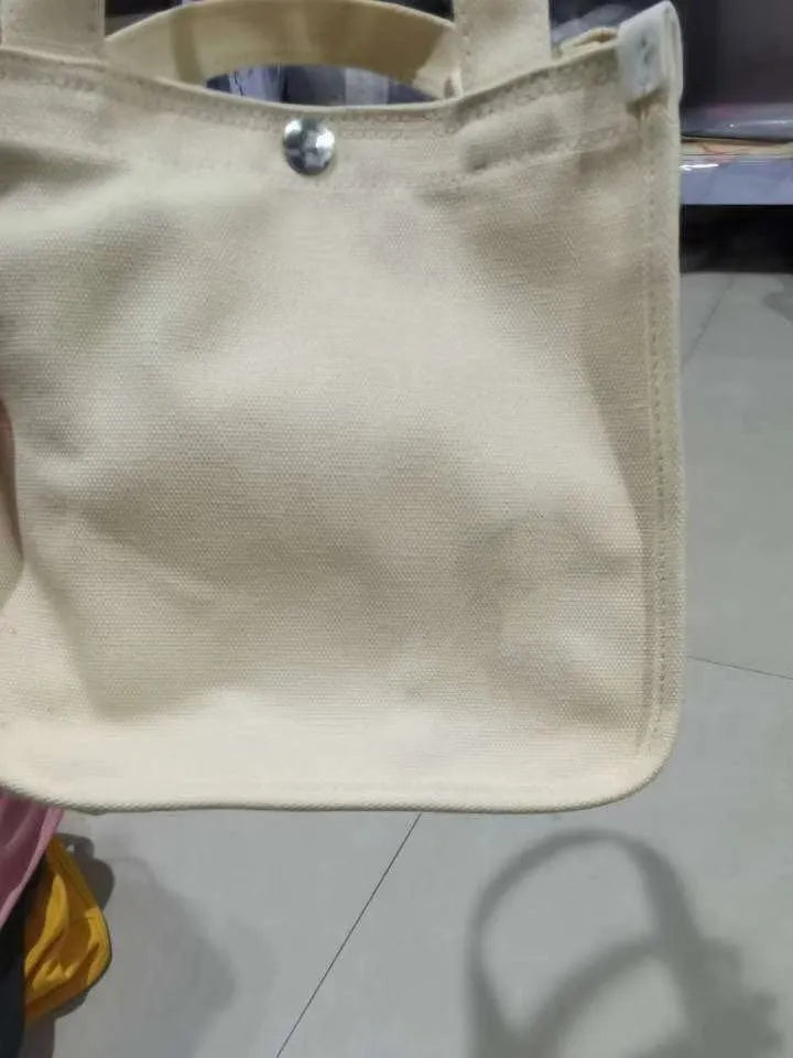 Canvas small square tote bag with magnetic buckle and zipper pocket in black, khaki, red, or white.