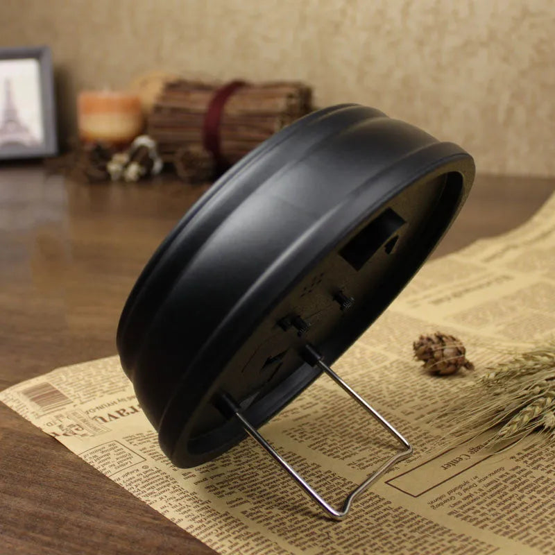Round European retro style desk clock with silent alarm on a wooden desk.