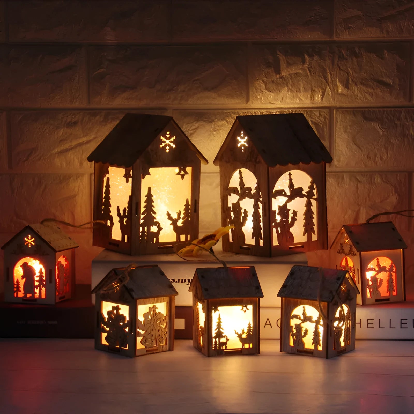 Set of three handmade wooden Christmas decorations: a log bell and two rustic houses with old man and snowman.