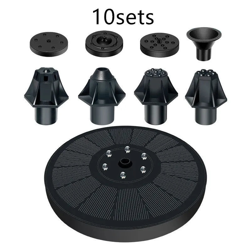 Black solar fountain pump with four spray nozzles on a green grass background next to a birdbath.
