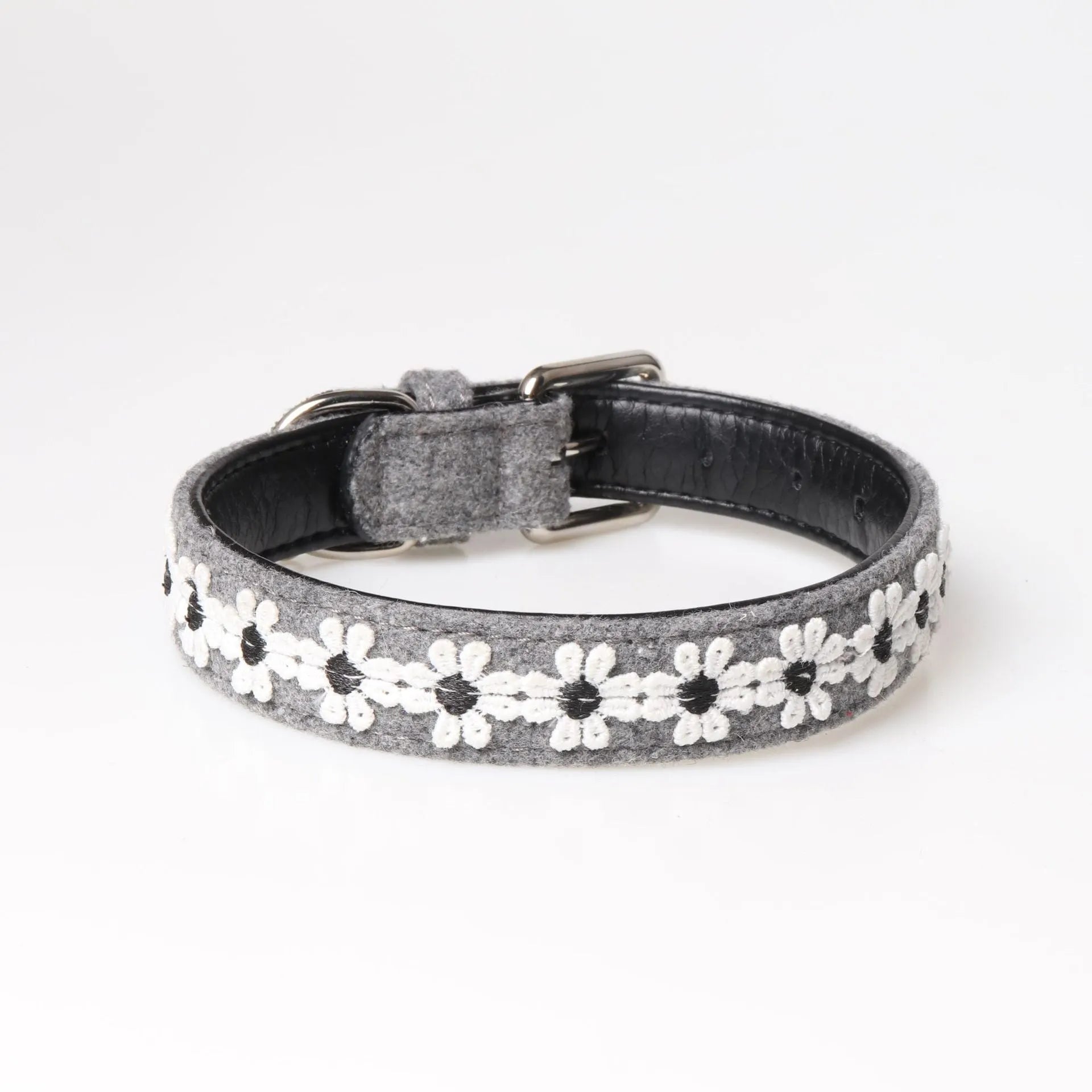 Embroidered PU dog collar with metal buckle on a neutral background, available in four colours and two adjustable sizes