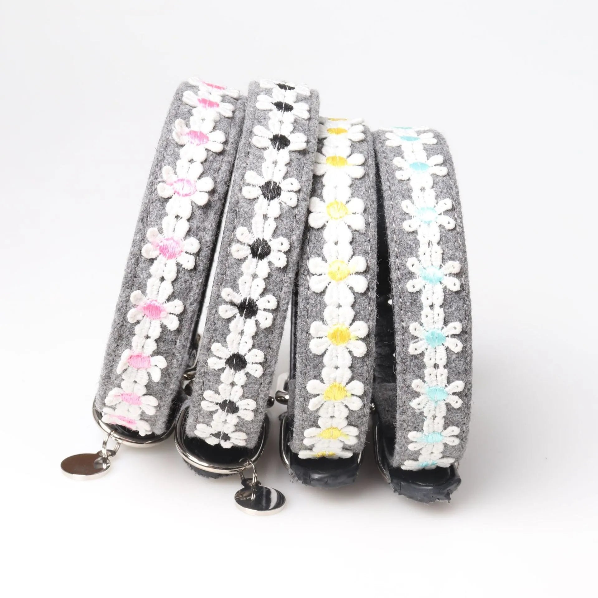 Embroidered PU dog collar with metal buckle on a neutral background, available in four colours and two adjustable sizes