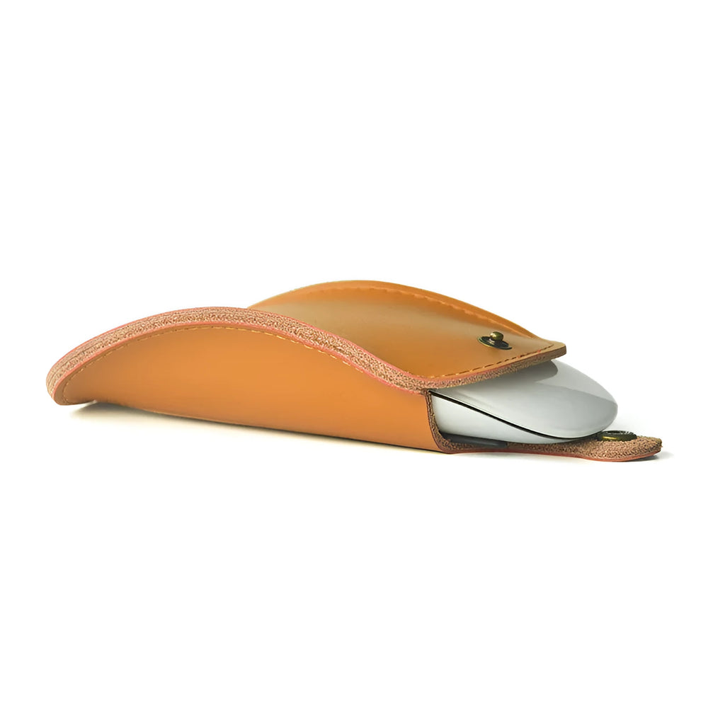 Brown leather storage bag for Apple Magic Mouse 2nd Generation, with a Magic Mouse partially visible inside, on a wooden desk.