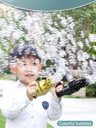 Child holding a pink bubble machine gun toy blowing a stream of bubbles outdoors.