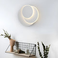 Modern round wall lamp with white acrylic shade and decorative circles on a wall.
