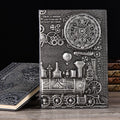 Retro embossed leather notepad in green bronze showing 3D European relief pattern on cover, lying open on a desk.