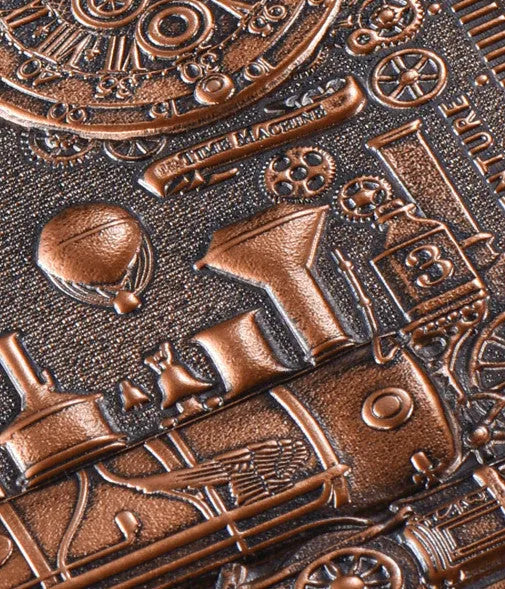 Retro embossed leather notepad in green bronze showing 3D European relief pattern on cover, lying open on a desk.