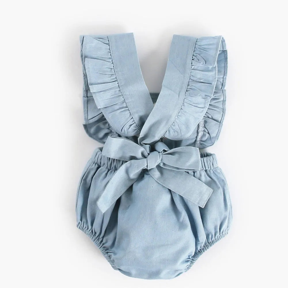Denim blue sleeveless baby girl romper with lace trim and triangle climb detail, shown on a hanger.