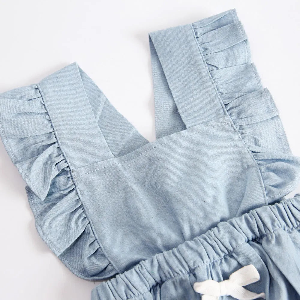 Denim blue sleeveless baby girl romper with lace trim and triangle climb detail, shown on a hanger.