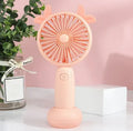 Hand-held USB charging mini fan in blue, green, pink, or yellow with cartoon style design