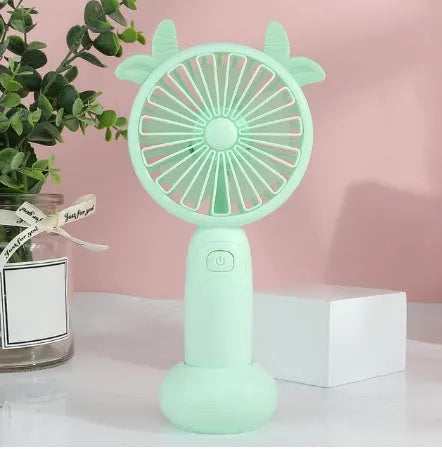 Hand-held USB charging mini fan in blue, green, pink, or yellow with cartoon style design