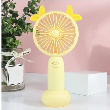 Hand-held USB charging mini fan in blue, green, pink, or yellow with cartoon style design