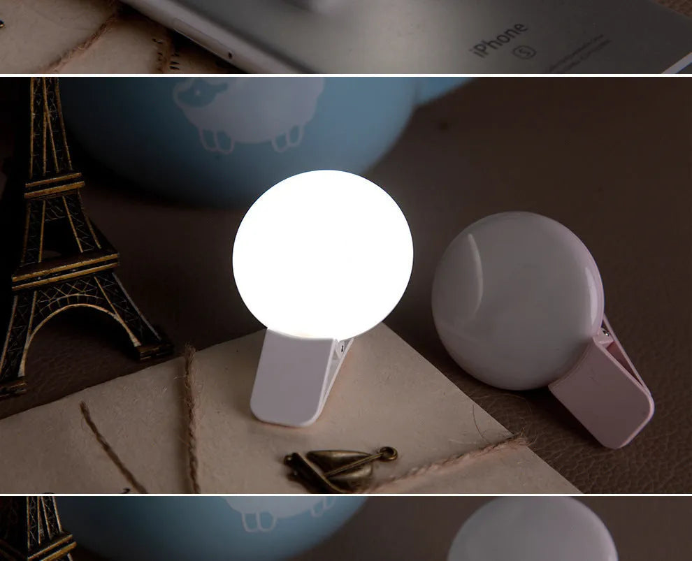 Round white mobile phone fill light clipped onto a smartphone for selfies.
