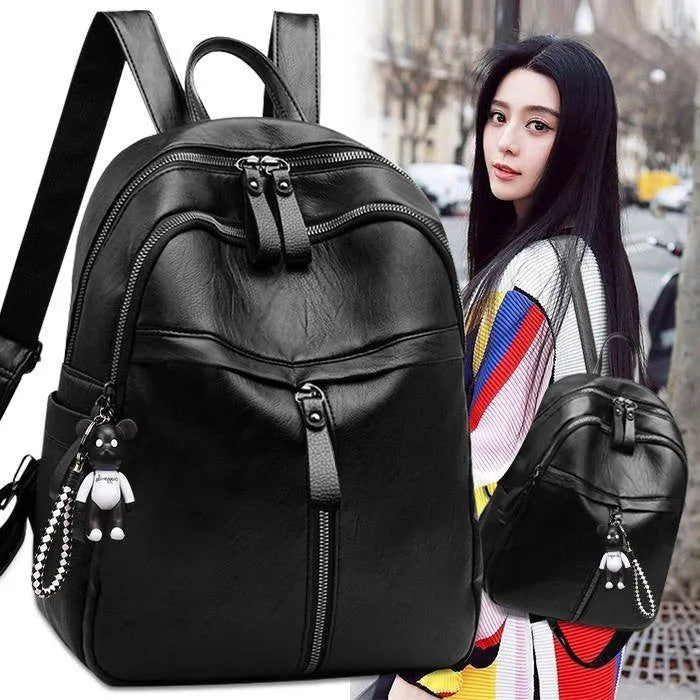 Medium black backpack with soft PU leather surface, showing double straps and zipper opening.