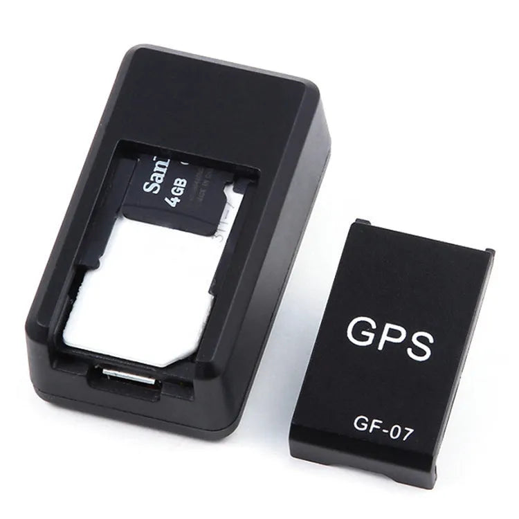 Small black magnetic GPS car tracker with USB charging cable on a metal surface.