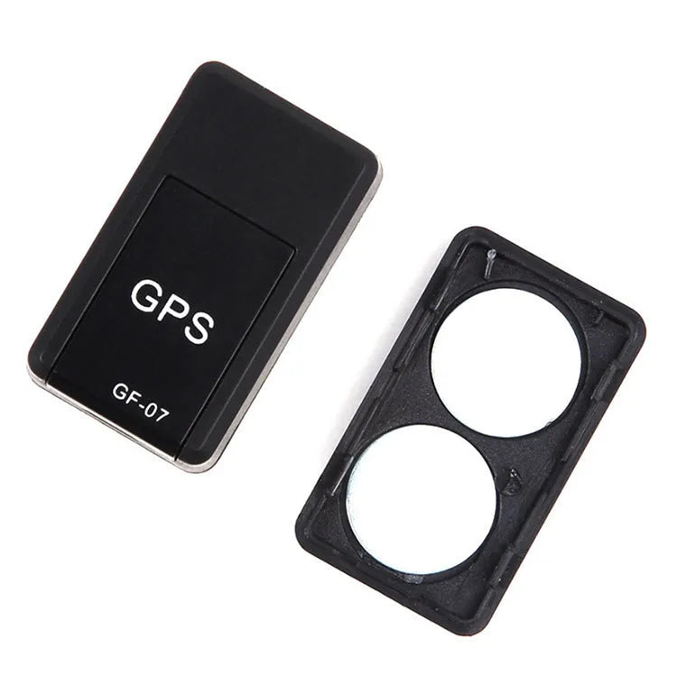 Small black magnetic GPS car tracker with USB charging cable on a metal surface.