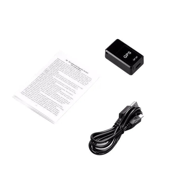 Small black magnetic GPS car tracker with USB charging cable on a metal surface.