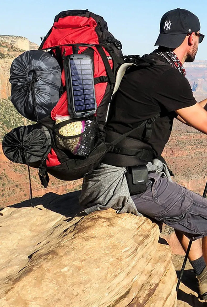 Orange XN-i26S solar power bank showing solar panel, camping light, and USB ports