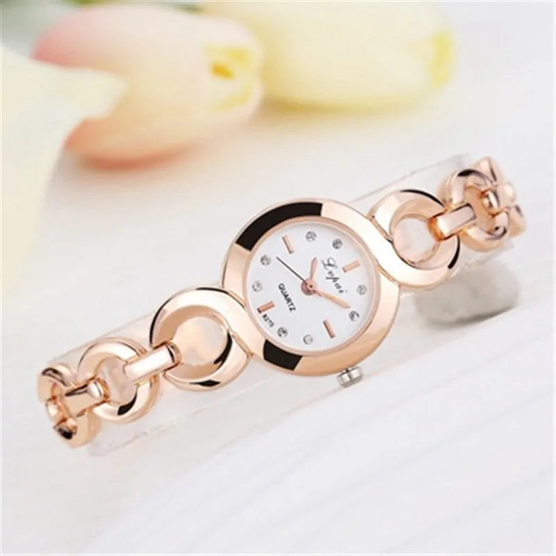 Gold alloy quartz watch with black dial on a white background showing strap and face