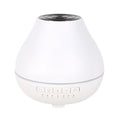White round Bluetooth aroma diffuser with night light on a wooden table, showing mist output and water level.