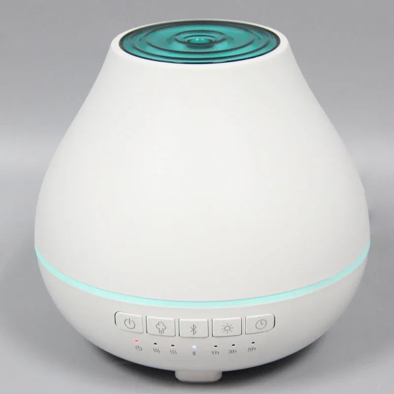 White round Bluetooth aroma diffuser and humidifier with night light on a wooden surface.