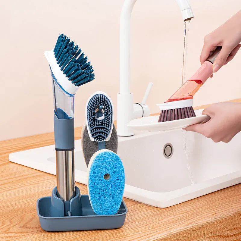 Blue long-handled kitchen dish brush with built-in soap dispenser button, sponge, and scouring block.