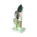 Blue long-handled kitchen dish brush with built-in soap dispenser button, sponge, and scouring block.