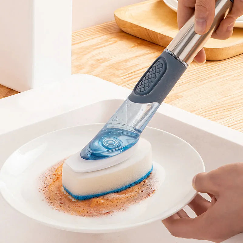 Blue long-handled kitchen dish brush with built-in soap dispenser button, sponge, and scouring block.