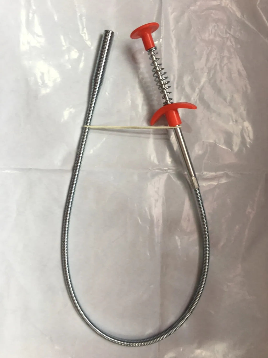 Flexible drain cleaning spring tool with gripped handle for removing hair from pipes