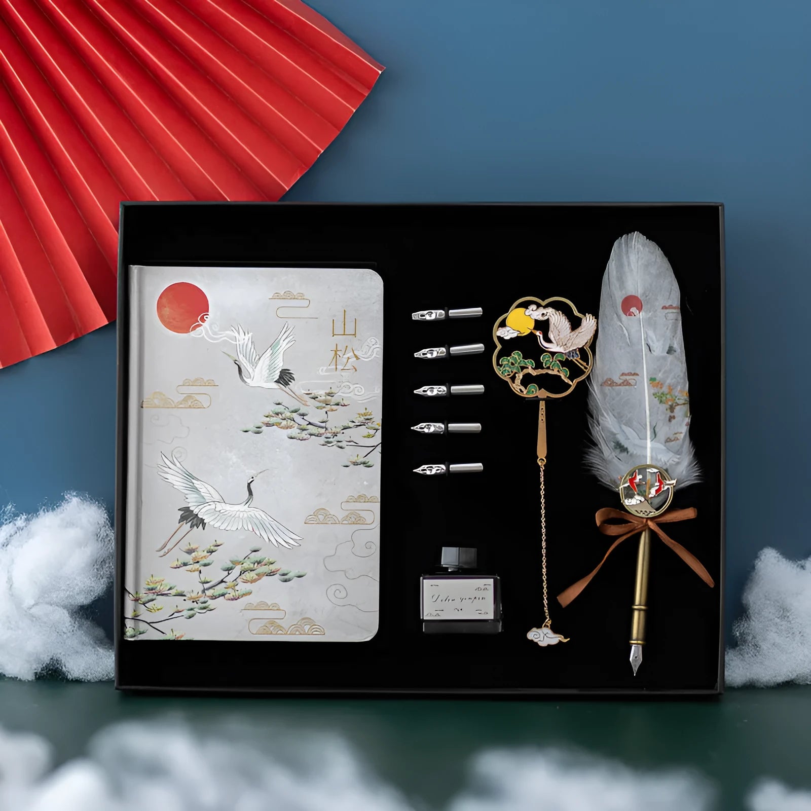 Traditional Chinese feather pen with metal shell and colourful feathers next to a Jianhegui notebook and pen sheath.