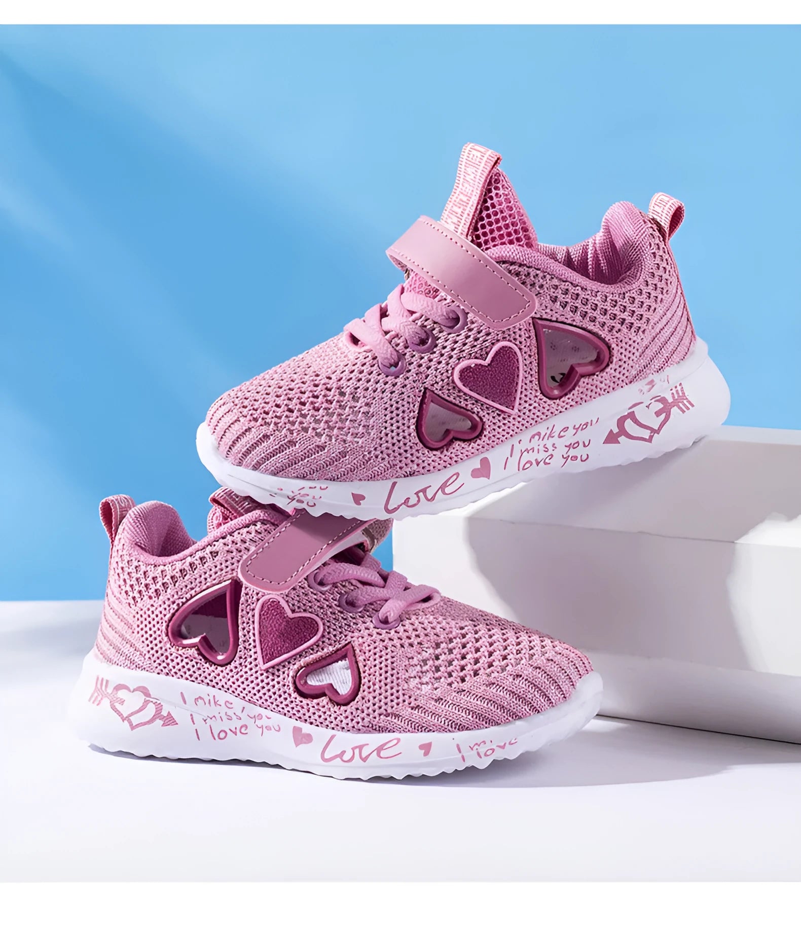 Kids pink cartoon mesh sneakers with Velcro strap on a white background.
