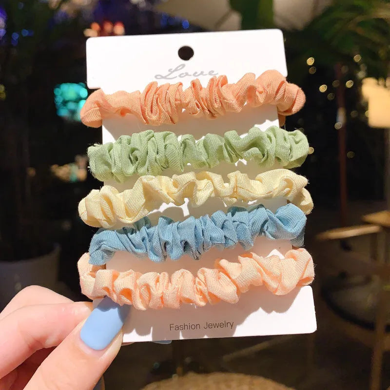 Assortment of children's hair rings and hair ropes in autumn colours and macaron pastels.