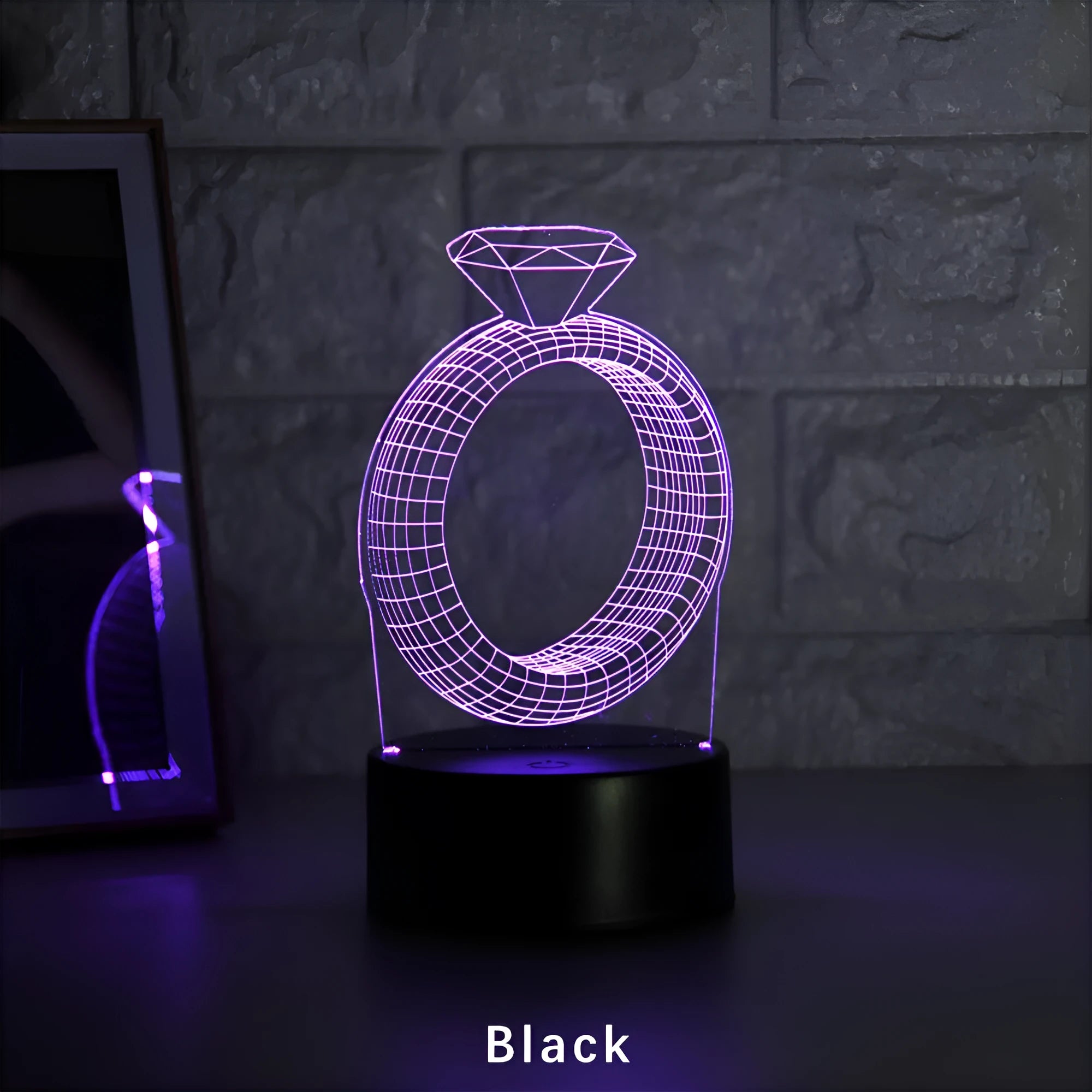 3D LED night light projecting a glowing diamond ring design on a black base with colour-changing effects.