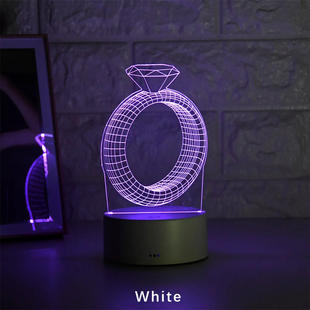 3D LED night light projecting a glowing diamond ring design on a black base with colour-changing effects.