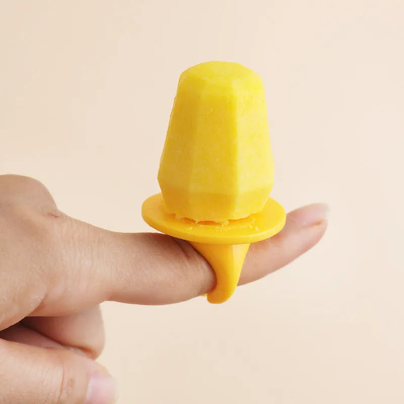 Soft plastic cartoon-style ice cream mould in brown honeycomb shape on a kitchen worktop.