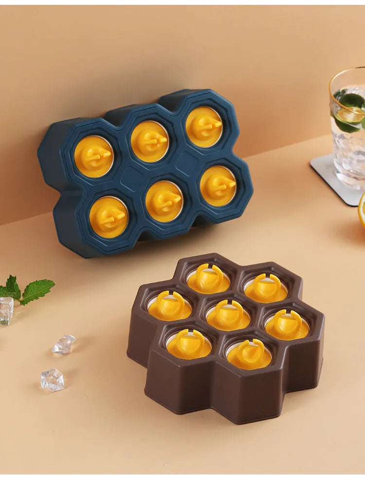 Soft plastic cartoon-style ice cream mould in brown honeycomb shape on a kitchen worktop.