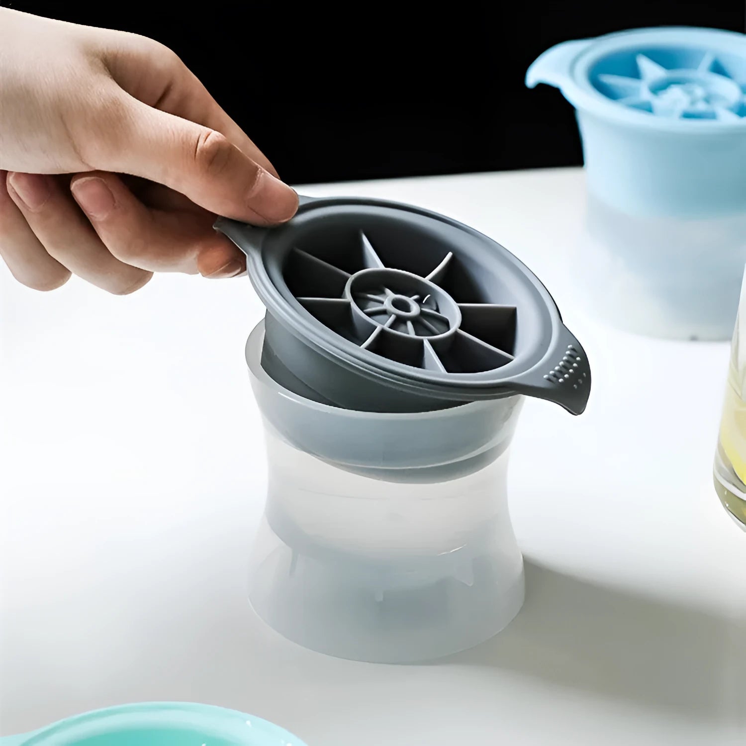 Silicone ice tray showing large hockey artefact and geometric round and pentagon ice cube moulds in assorted colours.