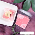 Pink self-adhesive plastic bag for packaging handmade soap bars on a table.