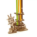 Assembled wooden desk pen holder with a steering wheel that rotates a central platform holding coloured pens.