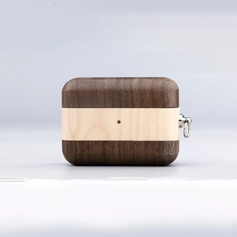 Solid wood earphone sleeve in walnut next to compatible wireless earphones on a wooden table.