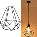 Black iron adjustable chandelier pendant light with retractable cord over a living room table.