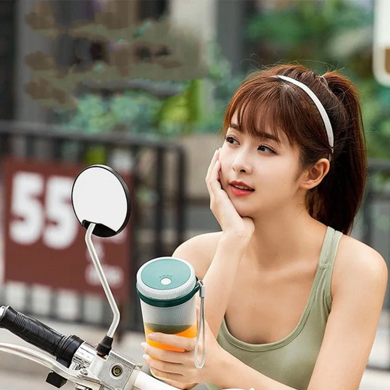 Portable pink electric juicer cup with USB charging cable on kitchen counter