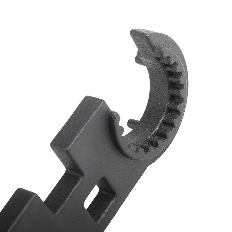 Black multi-function combination wrench for AR-15 and M4 rifles on a plain background.