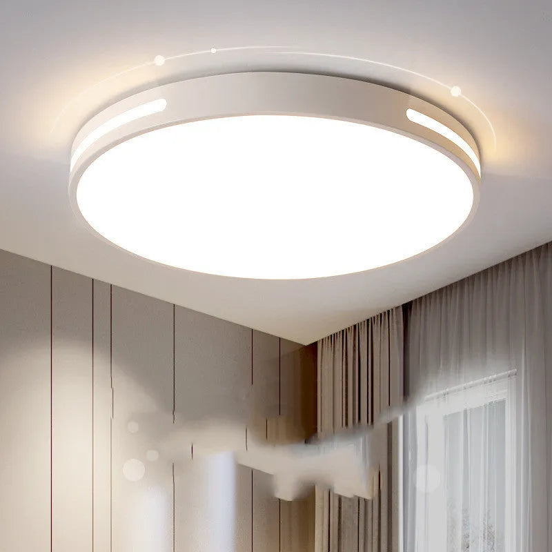 Round modern acrylic LED ceiling lamp with remote control on a white ceiling.