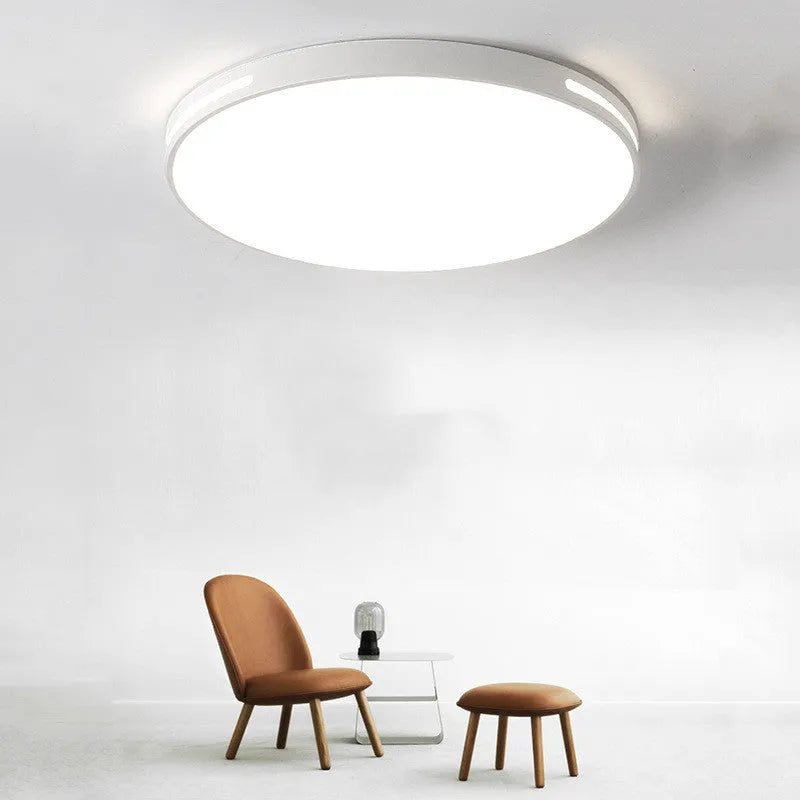 Round modern acrylic LED ceiling lamp with remote control on a white ceiling.