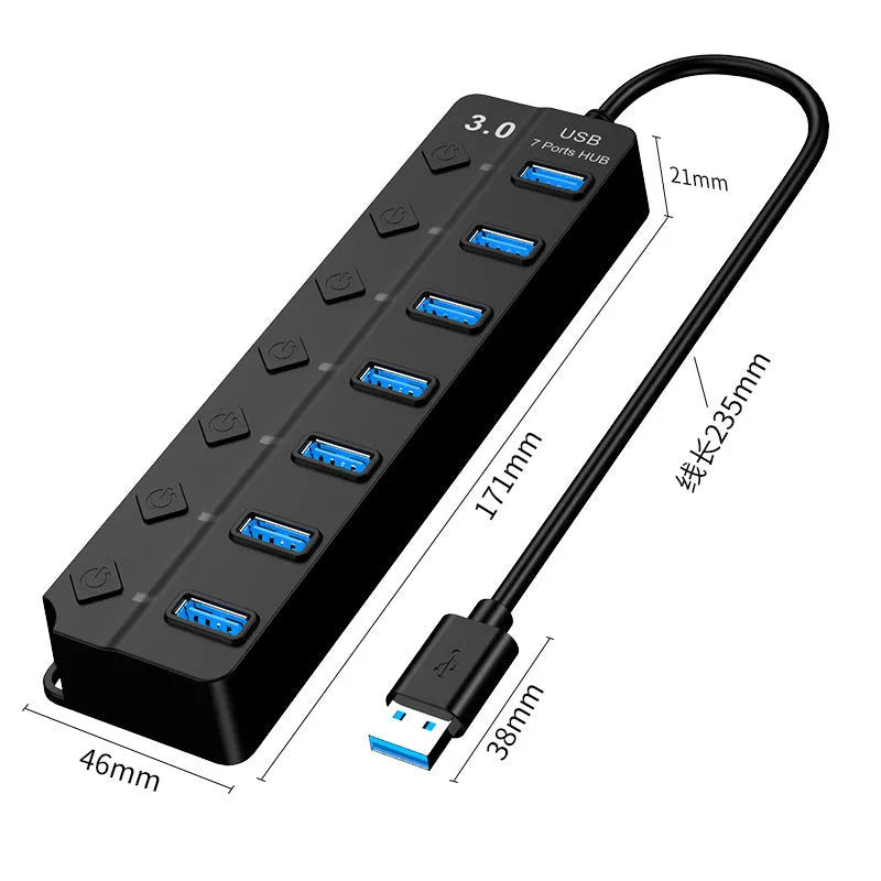 Black 7-port USB 3.0 hub with individual power switches and external power adapter on a wooden desk.
