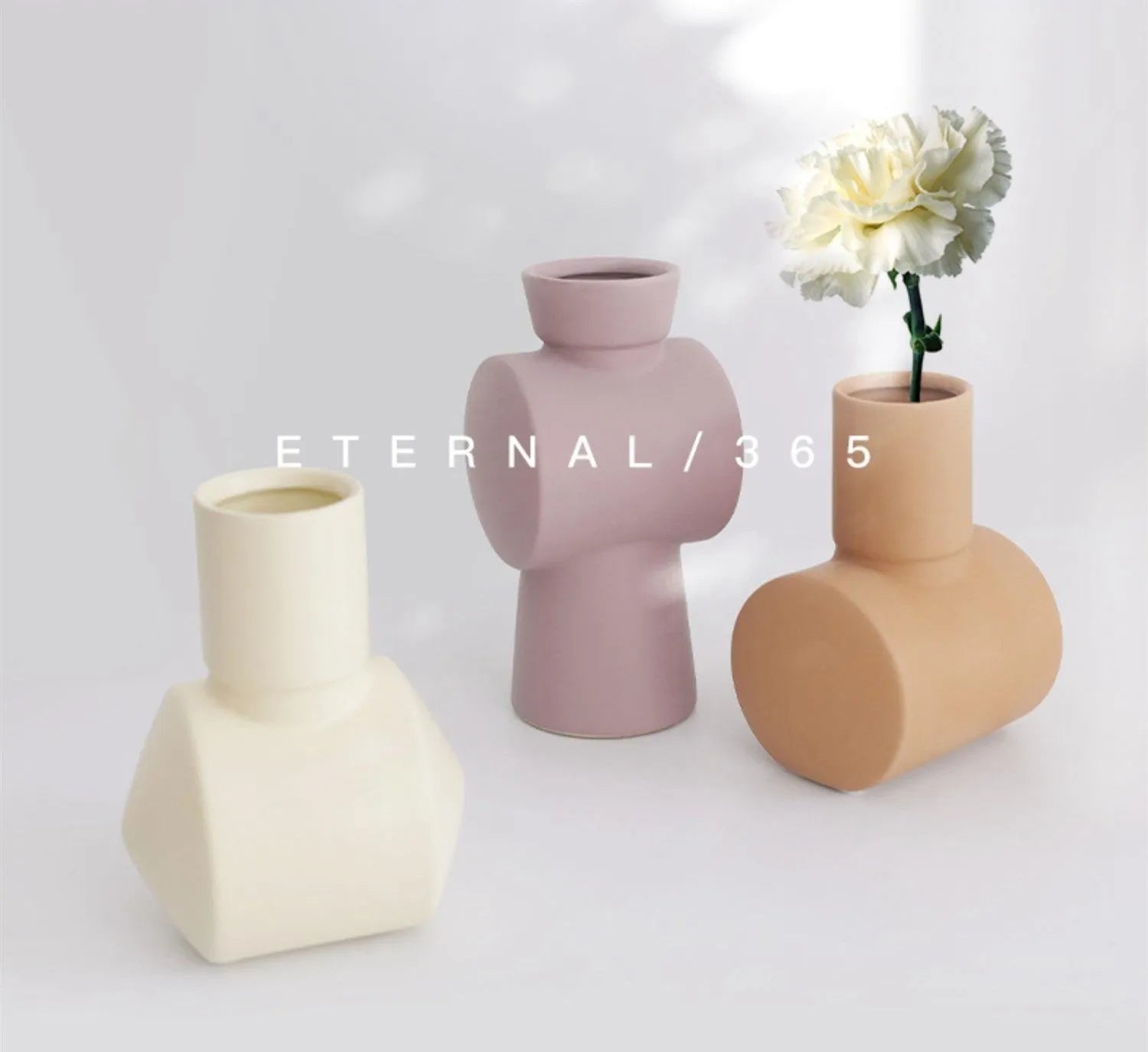 Hand-thrown white ceramic hammer vase in Morandi beige colour on a wooden table.